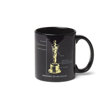Black ceramic mug with the design of the Oscar statuette and text detailing its anatomy.